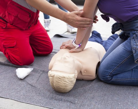 people performing cpr on mannequin 