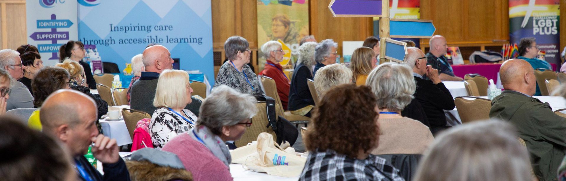 People sitting at tables at the unpaid carers conference 2023